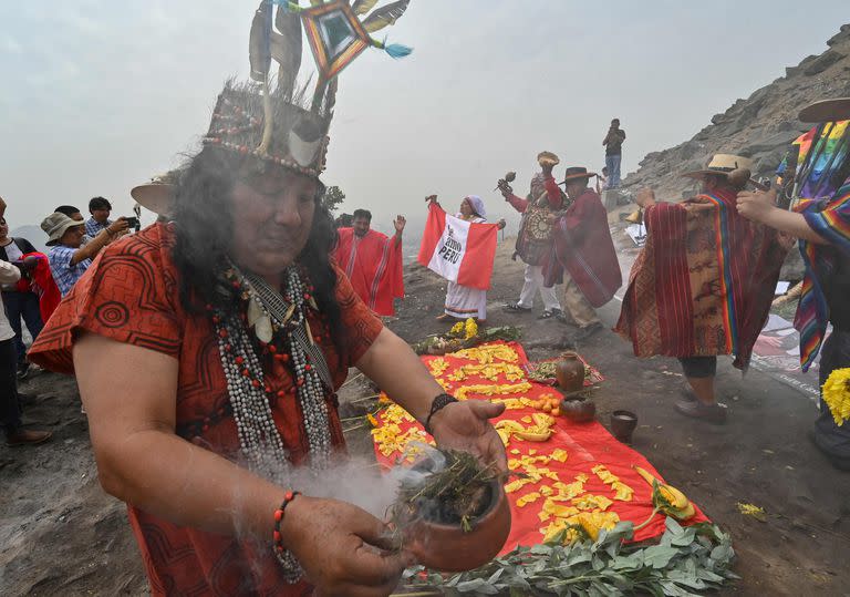 Chamanes peruanos equipados con hojas de coca, espadas, ollas de cerámica humeantes, incienso y una serpiente viva ejecutan un ritual en la cima de una colina sobre Lima para entregar sus predicciones para el el próximo año. Utilizan fotos de varios presidentes durante el encuentro.