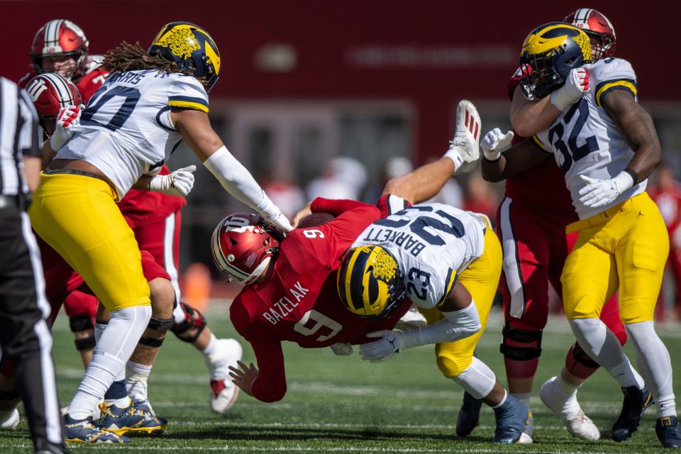 Indiana quarterback Connor Bazelak (9) is sacked hard by Michigan linebacker Michael Barrett during the first quarter Oct. 8, 2022 against Indiana at Memorial Stadium in Bloomington.