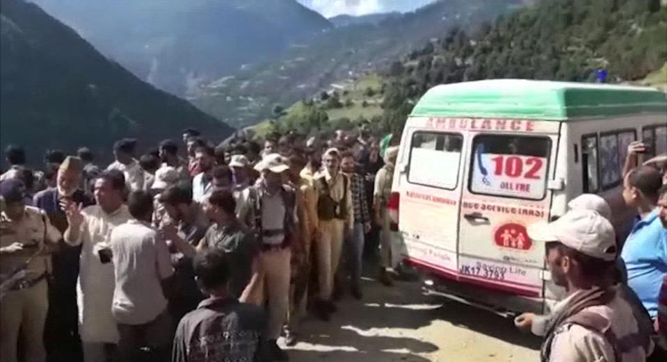 In this grab made from video provided by KK Productions, an ambulance waits to transport people injured in a bus accident in Kishtwar, about 217 kilometers (135 miles) southeast of Srinagar, Indian-controlled portion of Kashmir, Friday, Sept. 14, 2018. Police say a bus fell off a road into a deep gorge killing more than a dozen people and injuring an equal number. (KK Productions via AP)