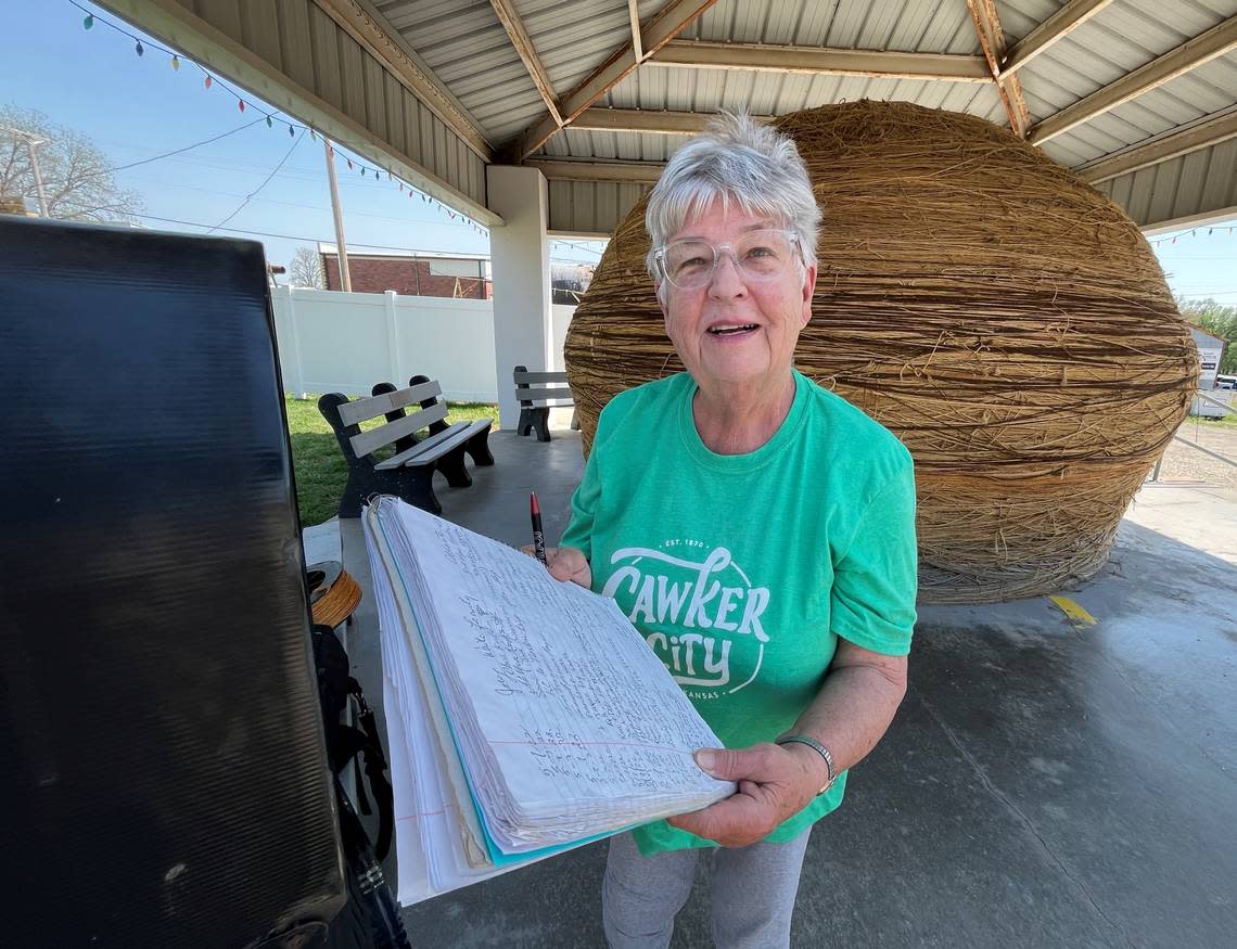 Linda Clover lists off dozens of visitors’ hometowns as written in the ball of twine’s guestbook.