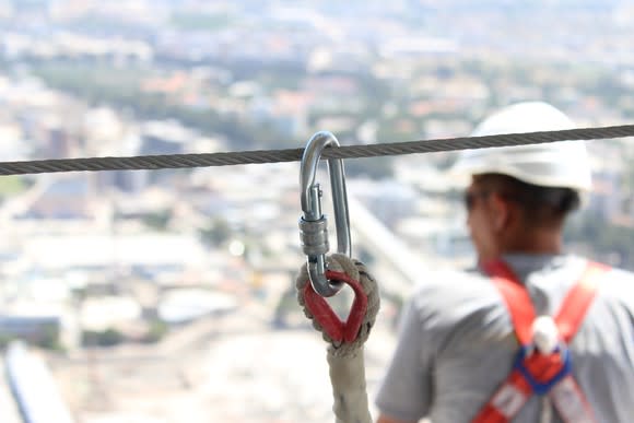 A construction worker connected to a safety line.