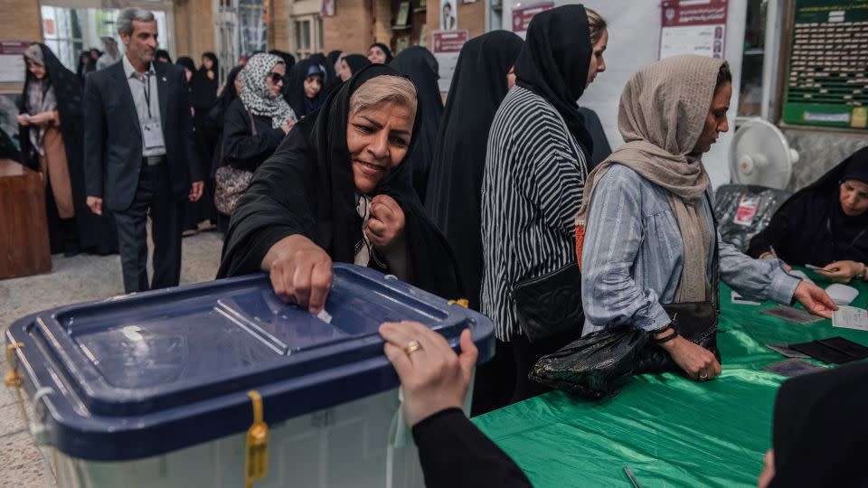 An Iranian woman casts her vote at a polling station during Iran's presidential election, in Tehran, Iran, on Friday. - Hossein Beris/Middle East Images/AFP/Getty Images