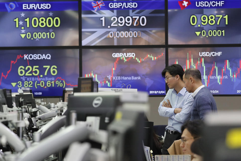 Currency traders watch monitors at the foreign exchange dealing room of the KEB Hana Bank headquarters in Seoul, South Korea, Wednesday, Dec. 4, 2019. Asian stock markets followed Wall Street lower after President Donald Trump cast doubt over the potential for a trade deal with China this year. (AP Photo/Ahn Young-joon)