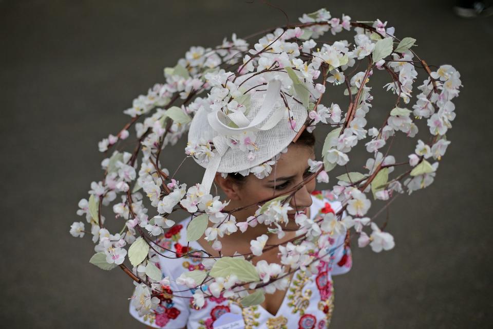 Flowers encircle this racegoer's headpiece on Day 1