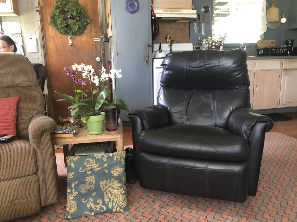 In this Dec. 11, 2020 photo provided by Ron Clark's roommate Suzanne Williams, Clark's favorite chair, right, sits empty in their home in Kapaa, Hawaii after Clark died of COVID-19 on the island of Kauai in November. Early and aggressive local measures coupled with a strictly-enforced statewide travel quarantine kept Kauai's 72,000 residents mostly healthy — the island had only 61 known coronavirus cases from March through September. But on Oct. 15, the state launched a pre-travel testing program to reignite Hawaii's decimated tourism economy. Kauai went from having no infections in early October to at least 84 new cases in seven weeks. The surge seeded community transmission and led to the island's first — and so far only — COVID-19 death: Ron Clark, who worked for decades as a tour driver. (Suzanne Williams via AP)