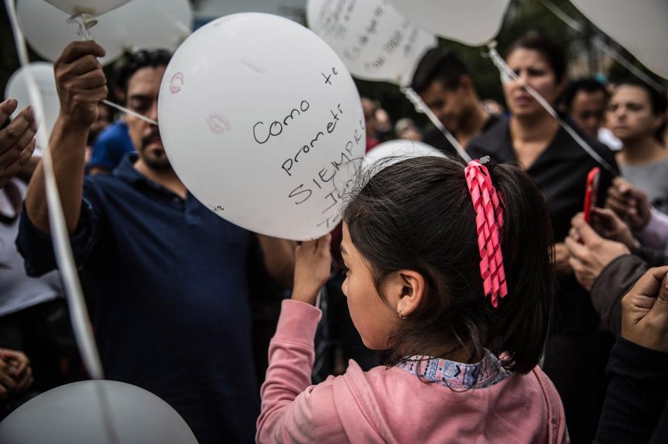 People write the names of victims and messages for them on balloons.&nbsp;