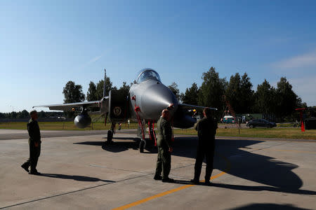 Polish Air Force officers look at U.S. Air Force F-15C Eagle fighter during NATO Baltic air policing mission takeover ceremony in Siauliai, Lithuania August 30, 2017. REUTERS/Ints Kalnins