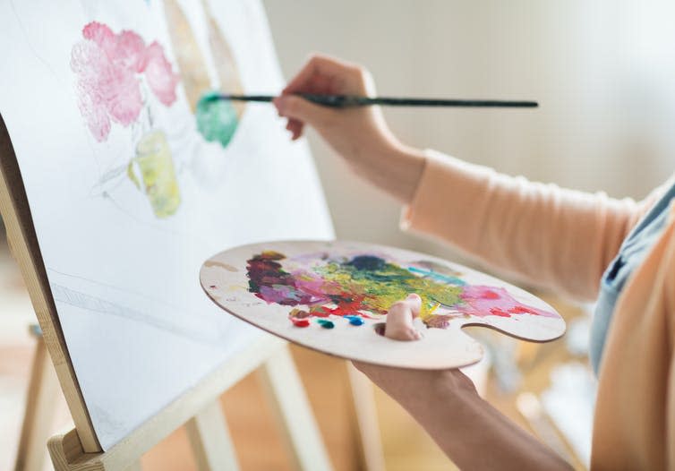 A woman painting on an easel