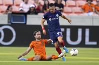 Houston Dynamo's Adam Lundqvist, left, challenges Chicago Fire's Stanislav Ivanov (99) for the ball during the first half of an MLS soccer game Saturday, June 25, 2022, in Houston. (AP Photo/David J. Phillip)