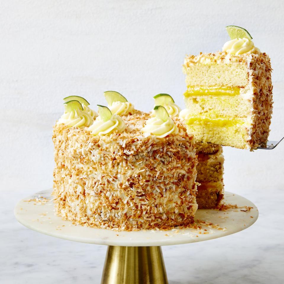 a layered coconut cake filled with lime curd and covered with toasted coconut