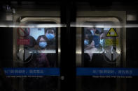 People wearing face masks to protect against the spread of the coronavirus ride on a subway train in Beijing, Wednesday, Jan. 27, 2021. China has given more than 22 million COVID vaccine shots to date as it carries out a drive ahead of next month's Lunar New Year holiday, health authorities said Wednesday. (AP Photo/Mark Schiefelbein)