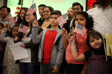 FILE PHOTO: Children say the pledge of allegiance during a ceremony to present citizenship certificates to young people who earned citizenship through their parents, in Los Angeles, California, U.S., May 31, 2017. REUTERS/Lucy Nicholson/File Photo