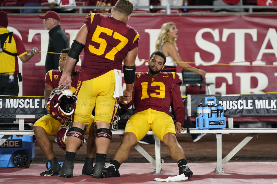Southern California quarterback Caleb Williams (13) reacts with offensive lineman Justin Dedich (57) and running back Austin Jones after the team's loss to Utah in an NCAA college football game, Saturday, Oct. 21, 2023, in Los Angeles. (AP Photo/Ryan Sun)