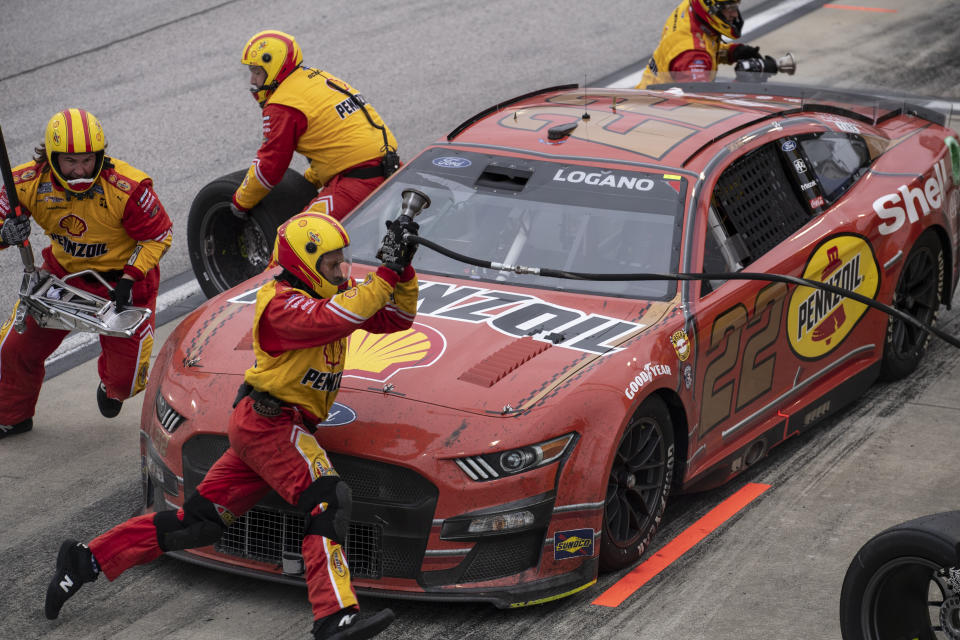 Pit crew members for Joey Logano (22) rush to complete a pit stop during a NASCAR Cup Series auto race at Darlington Raceway, Sunday, May 8, 2022, in Darlington, S.C. (AP Photo/Matt Kelley)