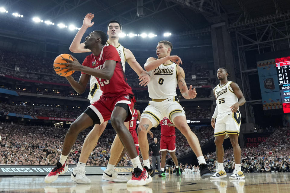 NC State forward Mohamed Diarra, left, drives as Purdue center Zach Edey defends during the second half of the NCAA college basketball game at the Final Four, Saturday, April 6, 2024, in Glendale, Ariz. (AP Photo/Brynn Anderson )