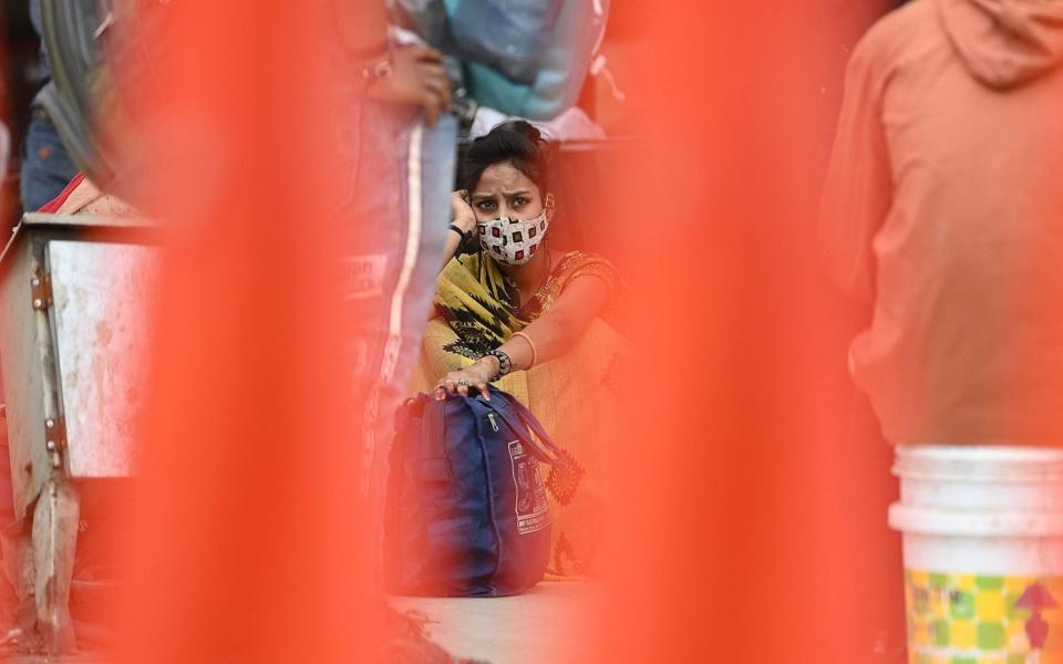 Migrant workers wait to get on a bus at a station in New Delhi and head home as aa record-breaking spike in coronavirus infections forces the capital into a week-long lockdown -  SAJJAD HUSSAIN/AFP