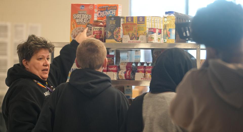 Food Service Manager Lauri Jones gives cooking tips as Minerva Park Middle School students pick up food Friday, Dec. 15, 2023, at the school's Panther Pantry designed to help students in need.