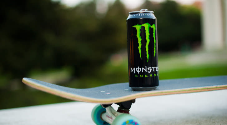 A can of Monster Beverage (MNST) energy drinks sits on top of a skateboard.