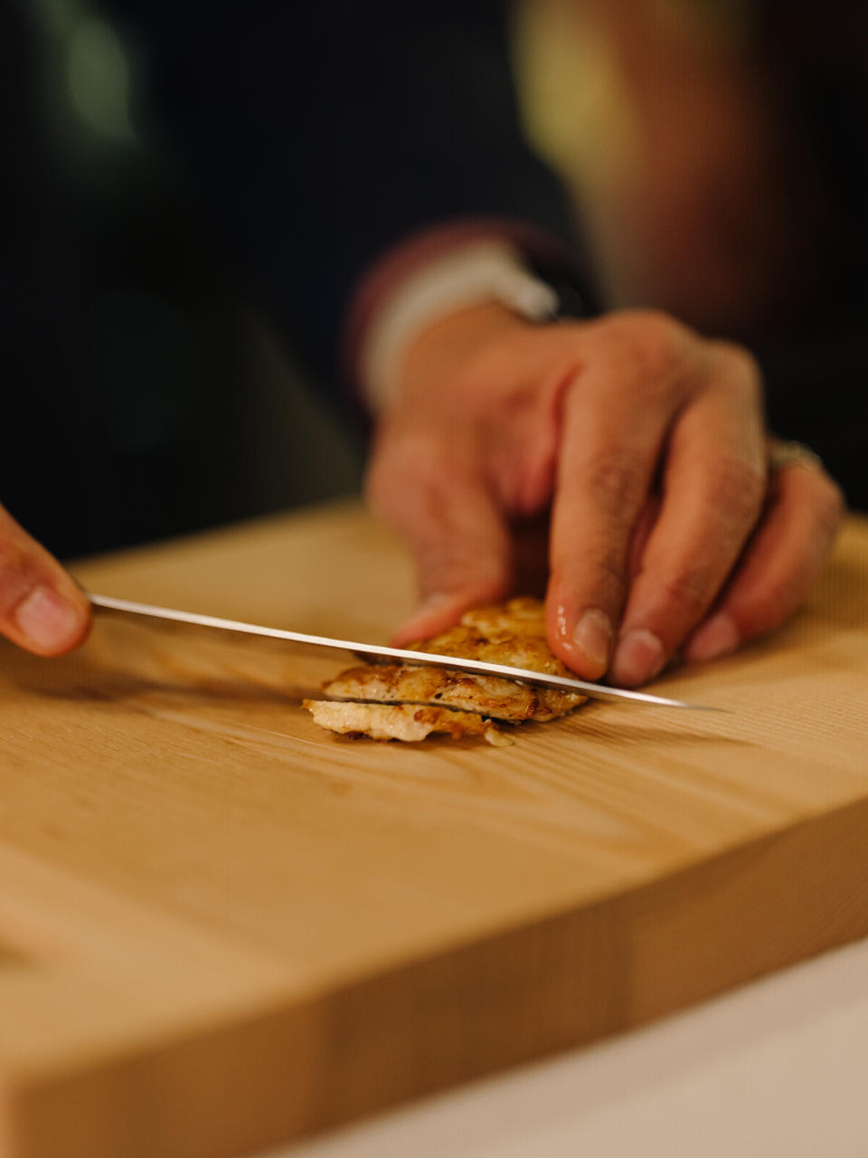 Upside Foods' founder, Uma Valeti, slices the freshly cooked lab-grown chicken product<span class="copyright">Rozette Rago for TIME</span>