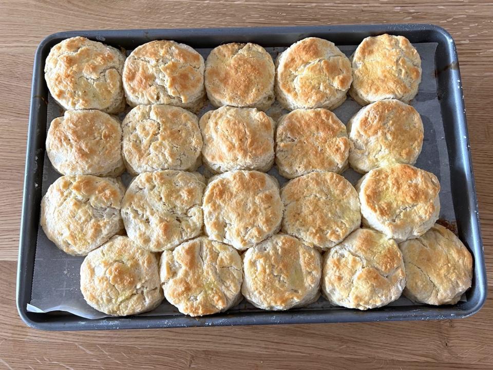 A tray full of biscuits sits on a wood surface.