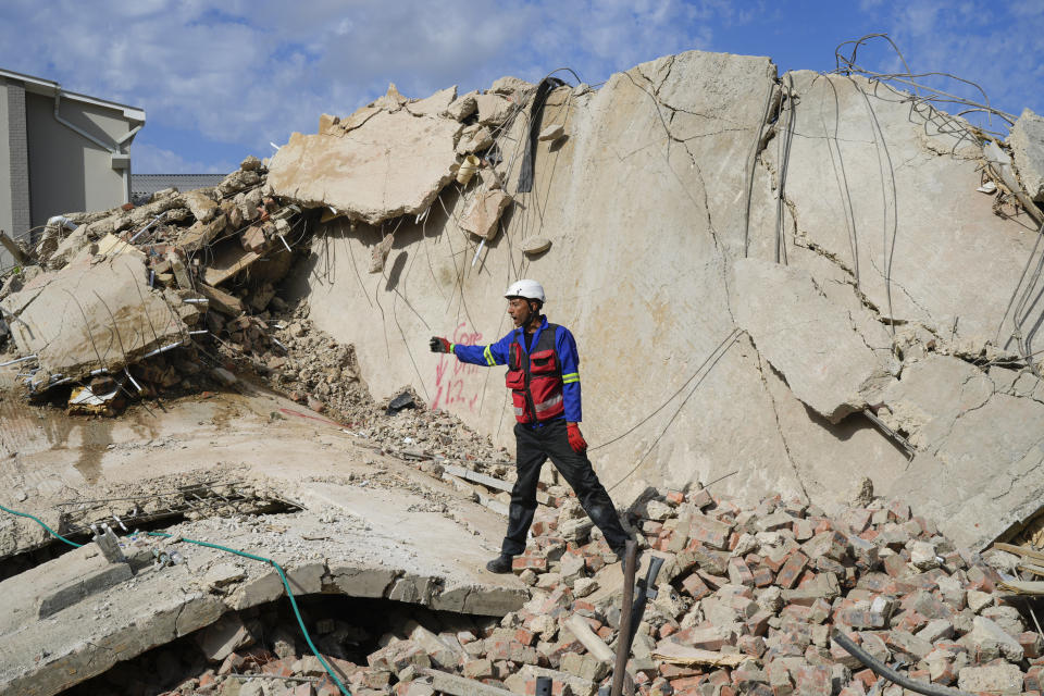 Rescue workers search the site of a building collapse in George, South Africa, Wednesday, May 8, 2024. Rescue teams are searching for dozens of construction workers missing after a multi-story apartment complex collapsed in the coastal city have brought out more survivors as the operation entered a second night of desperate work to find anyone alive in the mangled wreckage. (AP Photo/Jerome Delay)