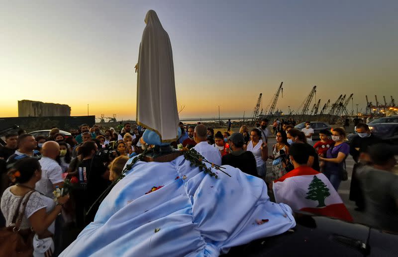 People attend a prayer near the site of a massive explosion in Beirut