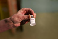 Chief nurse nurse Sam Foster holds a vial of the Oxford University/AstraZeneca COVID-19 vaccine, at the Churchill Hospital in Oxford, England, Monday, Jan. 4, 2021. England’s National Health Service says a retired maintenance manager has received the first injection of the new vaccine developed by between Oxford University and drug giant AstraZeneca. Dialysis patient Brian Pinker became the very first person to be vaccinated by the chief nurse at Oxford University Hospital. (Steve Parsons/Pool Photo via AP)