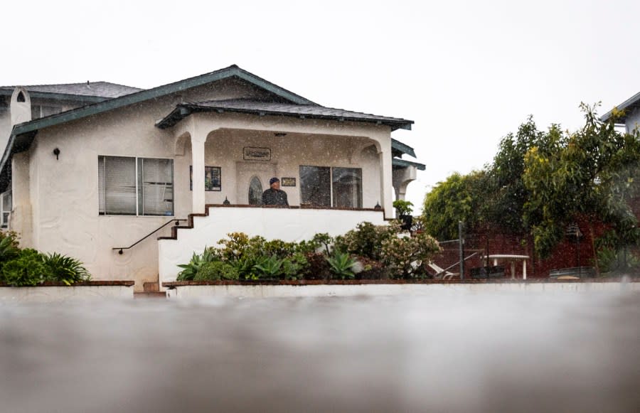 A resident watches as floodwaters rise during a rainstorm, Sunday, Feb. 4, 2024, in Santa Barbara, Calif. (AP Photo/Ethan Swope)