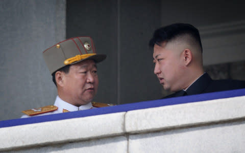 A man believed to be Choe Ryong-Hae talks with Kim Jong-un - Credit: AFP