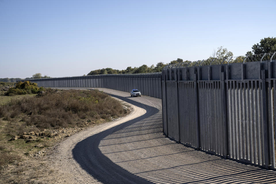 A police border vehicle patros along a border wall near the town of Feres, along the Evros River which forms the the frontier between Greece and Turkey on Sunday, Oct. 30, 2022. GGreece is planning a major extension of a steel wall along its border with Turkey in 2023, a move that is being applauded by residents in the border area as well as voters more broadly. (AP Photo/Petros Giannakouris)
