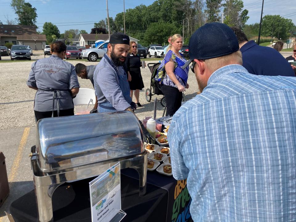 Fabian Martinez, chef de cuisine at Cedar and Sage Grill House in the Radisson Hotel & Conference Center Green Bay, serves up samples of the restaurant's fare to visitors at the Discover Green Bay visitors center announcement Tuesday.