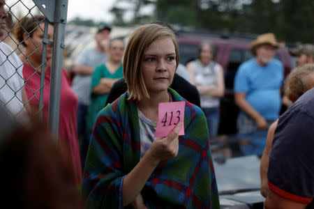 A woman displays her number as she enters the Remote Area Medical Clinic in Wise, Virginia, U.S., July 21, 2017. REUTERS/Joshua Roberts