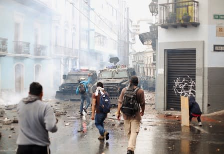 Demonstrators clash with riot police during a protest after Ecuadorian President Lenin Moreno's government ended four-decade-old fuel subsidies, in Quito