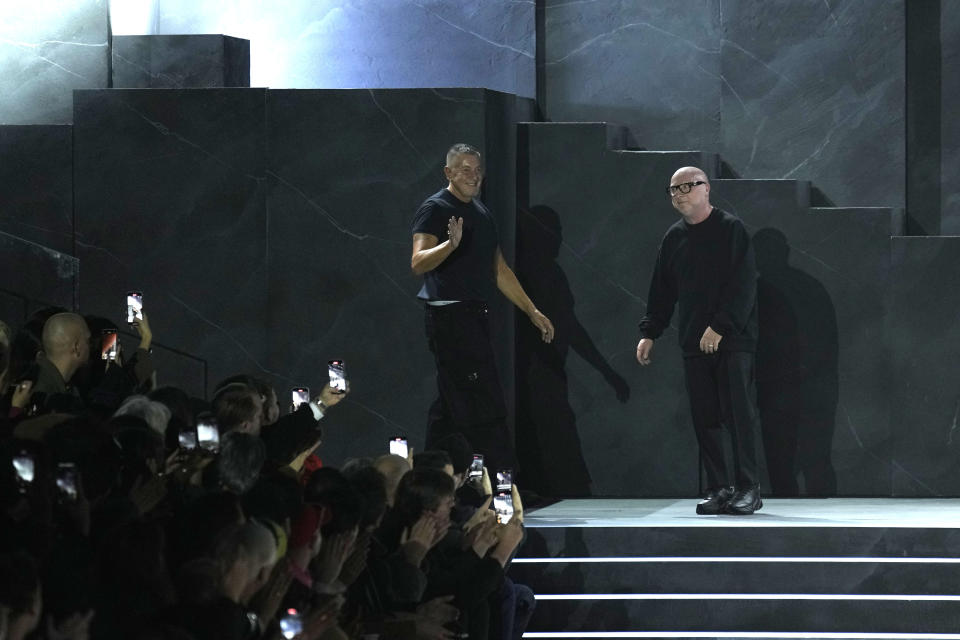 Stefano Gabbana, left, and Domenico Dolce accept applause after the Dolce & Gabbana, menswear Fall-Winter 2023-24 collection show in Milan, Italy, Saturday, Jan. 14, 2023. (AP Photo/Antonio Calanni)