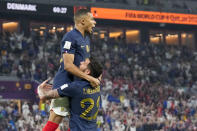 France's Kylian Mbappe celebrates with teammate Theo Hernandez after scoring his side's opening goal against Denmark during a World Cup group D soccer match at the Stadium 974 in Doha, Qatar, Saturday, Nov. 26, 2022. (AP Photo/Martin Meissner)