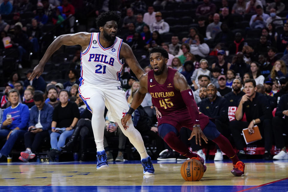 Cleveland Cavaliers' Donovan Mitchell, right, tries to get past Philadelphia 76ers' Joel Embiid during the first half of a preseason NBA basketball game, Wednesday, Oct. 5, 2022, in Philadelphia. (AP Photo/Matt Slocum)