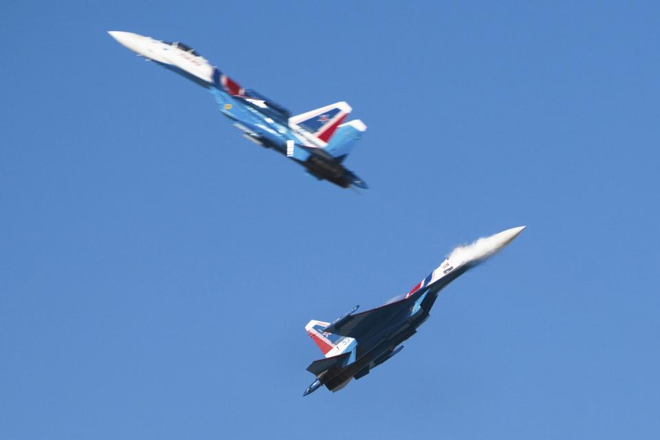 Members of the Russian air force's Russian Knights precision flying squad pass so close to each other that the jet wash can be seen over one of the aircraft at the Dubai Air Show in Dubai, United Arab Emirates, Monday, Nov. 13, 2023. Long-haul carrier Emirates opened the Dubai Air Show with a $52 billion purchase of Boeing Co. aircraft, showing how aviation has bounced back after the groundings of the coronavirus pandemic, even as Israel's war with Hamas clouds regional security. (AP Photo/Jon Gambrell)