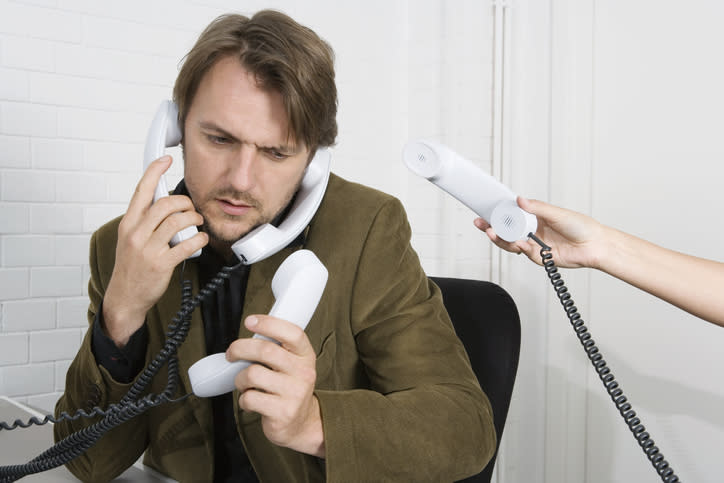 person holding 3 phones