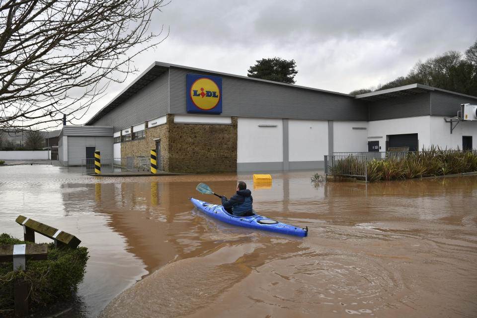 A man travels by boat through floodwater in Monmouth, Wales, Tuesday Feb. 18, 2020. Britain's Environment Agency issued severe flood warnings Monday, advising of life-threatening danger after Storm Dennis dumped weeks' worth of rain in some places. (Ben Birchall/PA via AP)