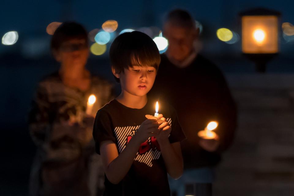 November 2, 202:2 El Pasoans holds candles at the Dia de Muertos ofrenda hosted in memory of El Paso and Uvalde gun violence victims at the El Paso County Healing Garden in Ascarate Park.