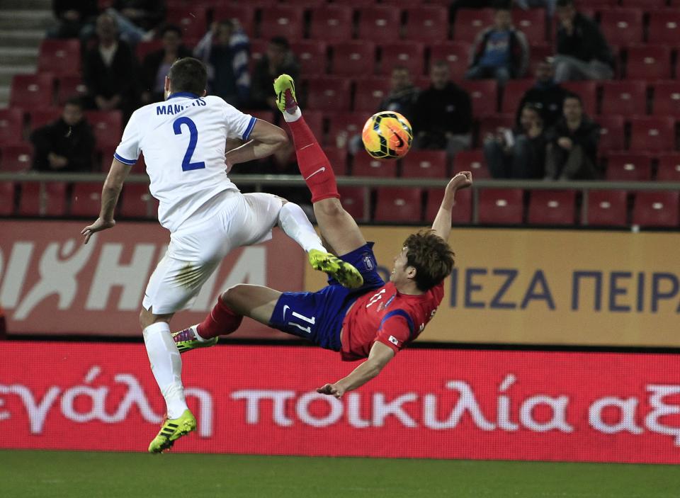 Greece's Giannis Maniatis, left, tries to stop South Korea's Son Heungmin as he shoots a cross kick during a friendly match at Georgios Karaiskakis stadium in Piraeus port, near Athens, Wednesday, March 5, 2014. (AP Photo/Thanassis Stavrakis)