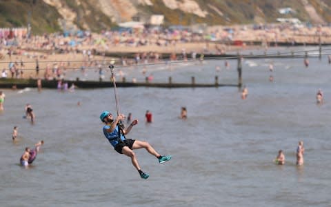 A person takes a ride on a zip wire from the pier to the beach in Bournemouth, Dorset - Credit: &nbsp;Andrew Matthews