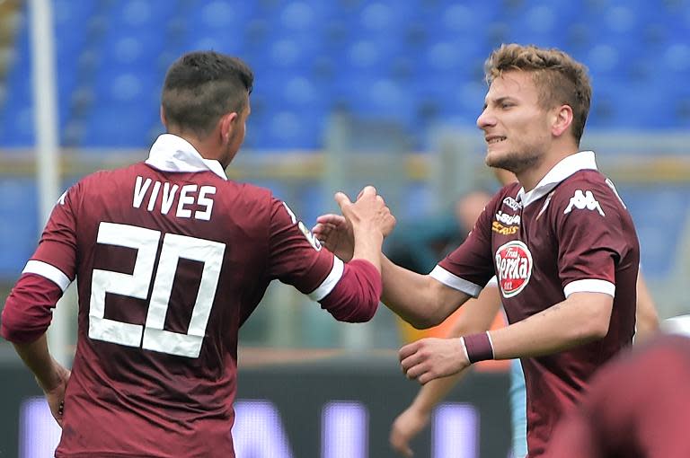 Torino's midfielder Giuseppe Vives congratulates Ciro Immobile (R) after his goal during an Italian Serie A football match against Lazio on April 19, 2014 at the Olympic stadium in Rome