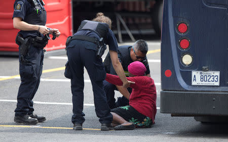 Canada Border Service agents help a woman who appeared to have fallen as she was walking to be processed at the Canada Border Services in Lacolle, Quebec, Canada August 11, 2017. REUTERS/Christinne Muschi