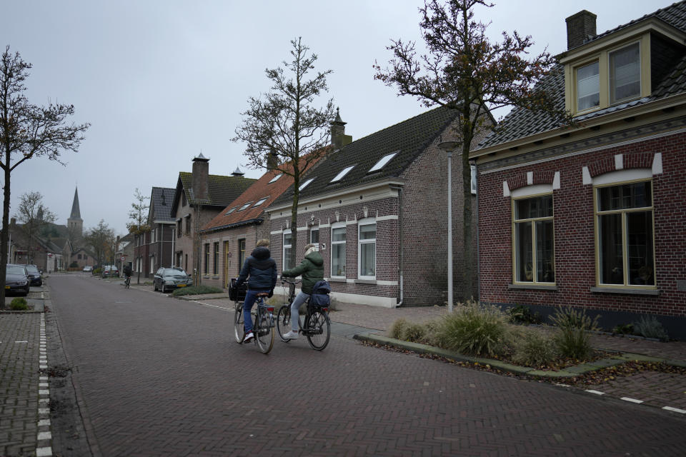 Two boys ride their bikes down a main street in Sprundel, Netherlands, Friday, Dec. 1, 2023. In the quiet Dutch village of Sint Willebrord, nearly three out of four voters chose a virulently anti-migrant, anti-Muslim party in an election last year that shattered the Netherlands' image as a welcoming, moderate country. Analysts say far-right parties are primed to gain influence over EU policies affecting everything from civil rights to gender issues to immigration. (AP Photo/Virginia Mayo)