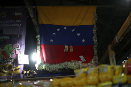 Venezuelan bolivar notes are seen on a Venezuelan flag in La Vega market in Santiago, Chile, May 10, 2018. REUTERS/Ivan Alvarado