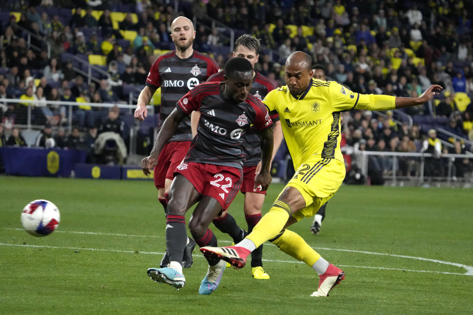 Nashville SC forward Teal Bunbury (12) gets a shot past Toronto FC midfielder Richie Laryea (22) during the second half of an MLS soccer match Saturday, April 8, 2023, in Nashville, Tenn. (AP Photo/Mark Humphrey)