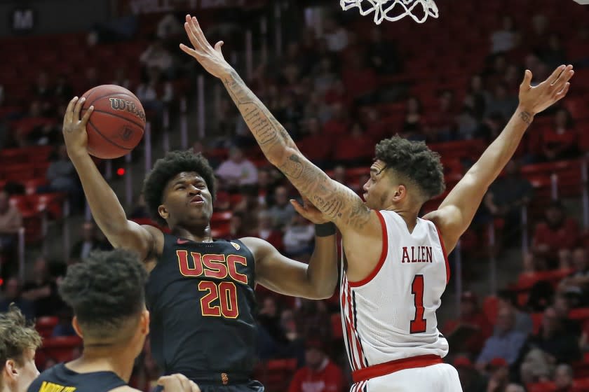 USC guard Ethan Anderson (20) goes to the basket as Utah forward Timmy Allen (1) defends in the first half of an NCAA college basketball game Sunday, Feb. 23, 2020, in Salt Lake City. (AP Photo/Rick Bowmer)