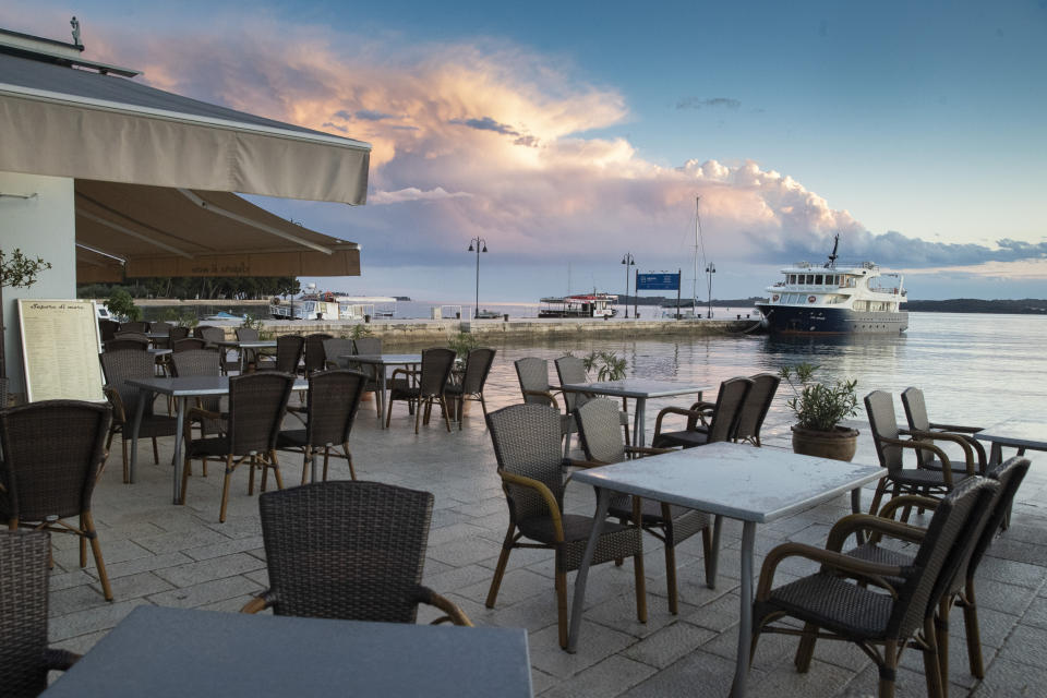 Kroatien, Fazana: Die Tische in den Cafés und Restaurants im Hafen von Fazana sind nicht besetzt. Das stark vom Tourismus abhängige Land an der Adria mit seiner langen, buchtenreichen Küste und den vielen Inseln kann es kaum erwarten, dass die europäischen Grenzen endlich aufgehen. Es geht mit eigenem Beispiel voran: Schon seit 9. Mai dürfen Ausländer, die eine Unterkunftsbuchung vorweisen können, ohne Corona-Test und ohne Quarantäne-Auflagen einreisen. Foto: Darko Bandic / AP / dpa