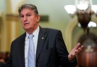 Senator Manchin speaks with an aide during a break in the impeachment trial in Washington